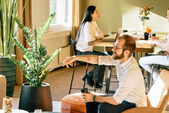 Mennesker jobber og prater i et coworkingområde i Skullerud Park